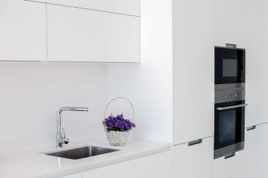 Beyaz mutfak iç kısmı. Minimalist iç tasarım. Modern mobilyalar ve dahili aletler.