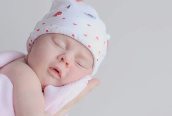 Menina Recém Nascida Com Boné Com Corações Está Dormindo Braço — Fotografia de Stock