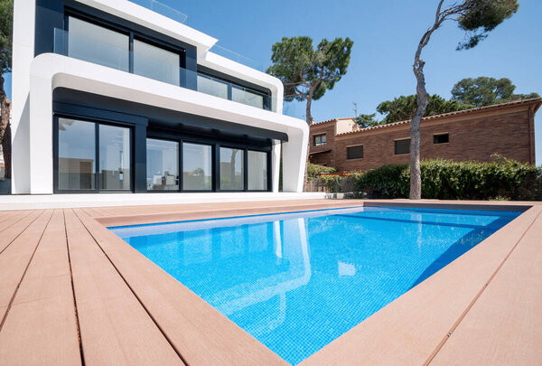 Luxurious villa with swimming pool at dusk. External view of a contemporary house. New technologies in construction.  