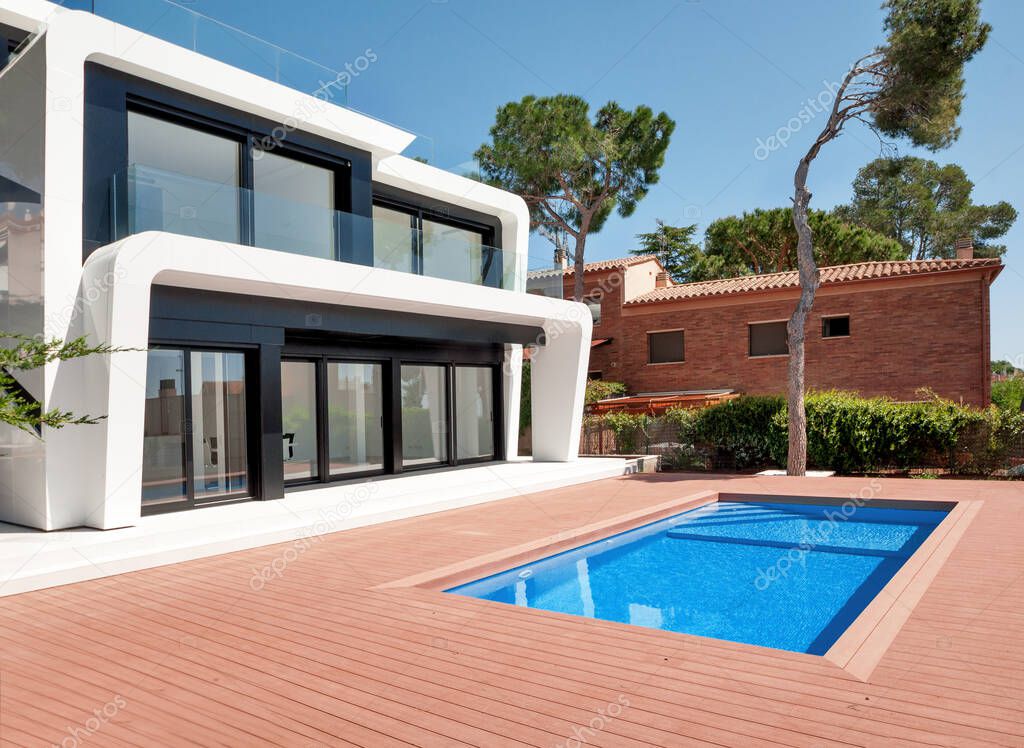 Luxurious villa with swimming pool at dusk. External view of a contemporary house. New technologies in construction.