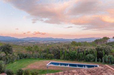 Havuzun ve manzaranın en üst görüntüsü. Bir kır evinin terasından gün batımının tadını çıkarıyorum..