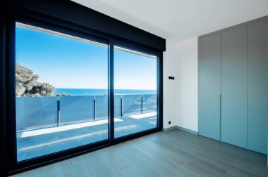 Denize bakan geniş pencereli yeni bir evde boş odalar. Otomatik jaluziler. Cam bölme terası.
