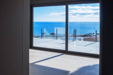 Denize bakan geniş pencereli yeni bir evde boş odalar. Otomatik jaluziler. Cam bölme terası.