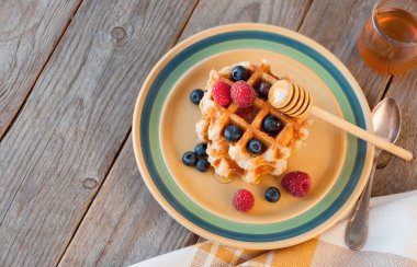 Taze ahududu ve ahşap arka planda yaban mersinli geleneksel waffle.. 