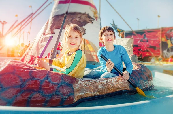 遊園地で遊んでいる子供たち カヌーに乗る 幸せな子供時代のコンセプト — ストック写真