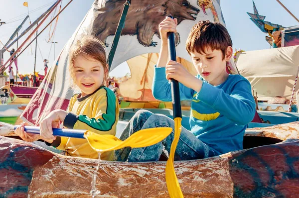 遊園地で遊んでいる子供たち カヌーに乗る 幸せな子供時代のコンセプト — ストック写真