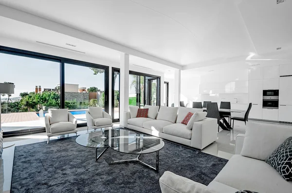 Lüks ve modern oturma odası, havuza erişimi olan büyük pencereli yemek odası. - Evet. Lüks mobilyalar, kanepe, masa ve sandalyeler..