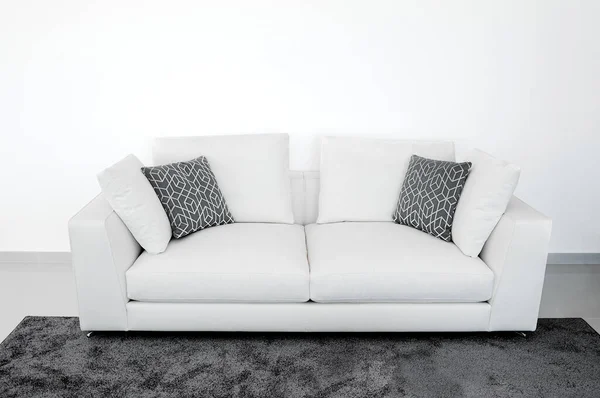 Biała Sofa Przy Białej Pustej Ścianie Szarymi Poduszkami Dywanem Szczegóły — Zdjęcie stockowe