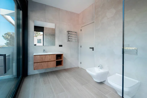 ガラスバスタブと豪華な洗面台付きのモダンなバスルーム 壁や床は近代的なタイルで覆われています — ストック写真