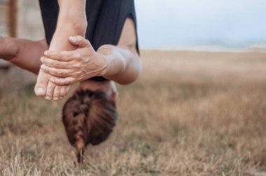 Kadın sinek yogası yapıyor. Dışarıda yerçekimi yogası. Spor ve sağlıklı yaşam tarzı kavramı. Uzayı kopyala Yoga yapan kadınların ellerini ve bacaklarını kapatın.. 