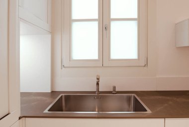 Modern mutfak lavabosu ve musluğu pencerenin yanında.. 
