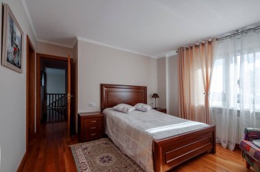 Ahşap zemini ve yatağı olan modern tasarımda rahat bir yatak odası..  