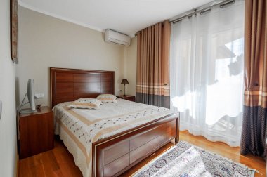 Ahşap zemini ve yatağı olan modern tasarımda rahat bir yatak odası..  