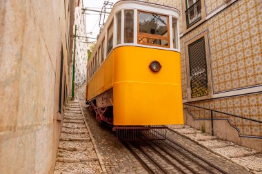 Lizbon sokaklarından birinde raylı sarı bir tramvay. Portekiz. 