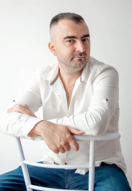 Beyaz gömlekli karizmatik bir adamın portresi. Kendine güvenen, güvenilir, arkadaş canlısı, sıradan biri..