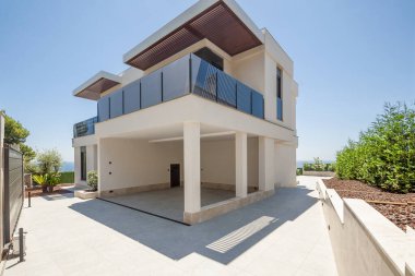 Modern evin ön cephesi yan taraftadır, bahçe ve bahçe düzenidir. Evdeki park yeri.