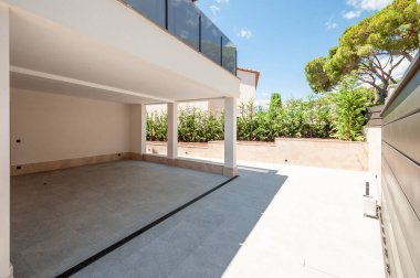 Modern evin ön cephesi yan taraftadır, bahçe ve bahçe düzenidir. Evdeki park yeri.