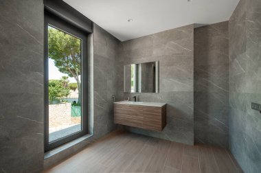Modern gri duş odası. Tepsisiz duş odası. Doğal malzemelerle kaplı duvarlar..  