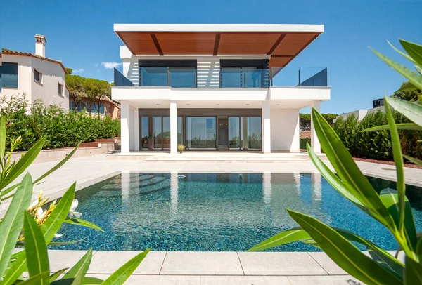 Geniş yüzme havuzlu lüks bir villanın modern cephesi. Lüks Modellik.