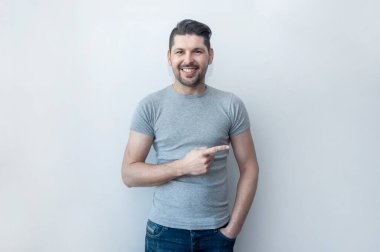 Yakışıklı, gülümseyen adam yeni bir teklif sunarken şaşkınlıkla işaret ediyor. Şuraya bakın! Dikkat, başparmak ile noktalar. 