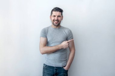 Yakışıklı, gülümseyen adam yeni bir teklif sunarken şaşkınlıkla işaret ediyor. Şuraya bakın! Dikkat, başparmak ile noktalar. 