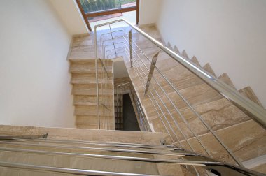 Çağdaş bir evde şeffaf ve cam parmaklıklı mermer adımlar..