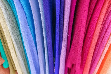 Farklı renklerde ince ince tişörtler örüyorlar. Renkli tekstil. Çarpık Renkli Gazlı Bez Grubu.