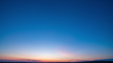 Yavaş sol kamera hareketi. Mavi gökyüzü ile doğal yeşil buğday tarlası ve güneşli bir günde bulutlar, gün doğumu. Doğal arka plan. Tarım arazisi, güzel renkli buğday, zaman aşımı, 4k hiperhız.