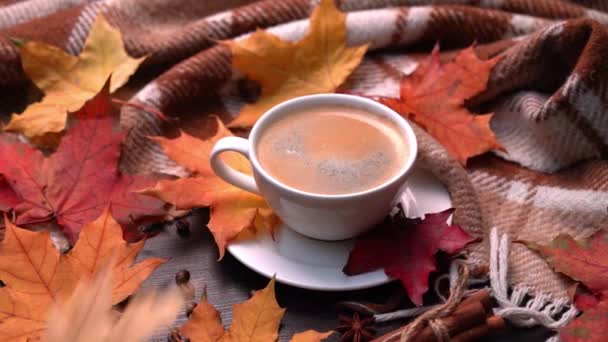 Ősz, őszi levelek, forró csésze kávé és meleg skót kockás fa asztal háttér. Szezonális, reggeli kávé, vasárnapi pihenés és csendélet koncepció. Fényképezőgép mozgása körben — Stock videók