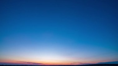 Yavaş sol kamera hareketi. Mavi gökyüzü ile doğal yeşil buğday tarlası ve güneşli bir günde bulutlar, gün doğumu. Doğal arka plan. Tarım arazisi, güzel renkli buğday, zaman aşımı, 4k hiperhız.