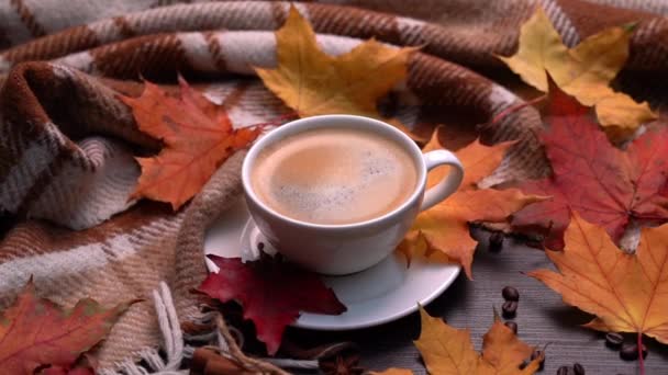 Otoño, hojas de otoño, taza de café caliente y cuadros calientes sobre un fondo de mesa de madera. Estacional, café de la mañana, domingo relajante y el concepto de naturaleza muerta. Movimiento de la cámara en círculo — Vídeo de stock