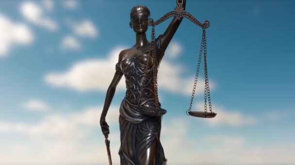Het standbeeld van rechtvaardigheid keert zich tegen de achtergrond van wolken die door de blauwe lucht bewegen. — Stockvideo