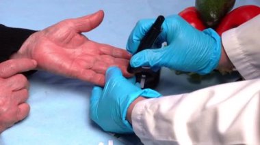Doktor kan şekeri testi yapıyor ve parmak ucundaki glukometreyle kan şekeri seviyesini ölçüyor. Diyabet Konseptinin Tıbbi ve Tedavi.