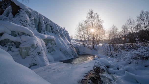 Hermoso paisaje de invierno, el movimiento del sol a través de un árbol en invierno, una cascada congelada, 4k, lapso de tiempo — Vídeos de Stock