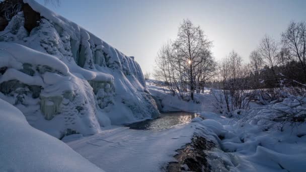 Όμορφο χειμερινό τοπίο, η κίνηση του ήλιου μέσα από ένα δέντρο το χειμώνα, ένας παγωμένος καταρράκτης, 4k, time lapse — Αρχείο Βίντεο