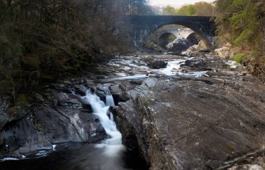 Şelale ve İskoçya 'daki Invermoriston köyünde nehri geçen iki köprü.