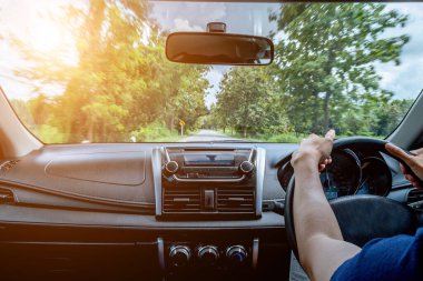 Otobanda dikiz aynasından araba süren bir adam yaz yolu boyunca manzaralı bir yerde araba sürüyor. Yaz gezisi.