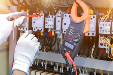Kontrol panelinde çoklu metre test cihazı olan elektrikçi ölçümleri.