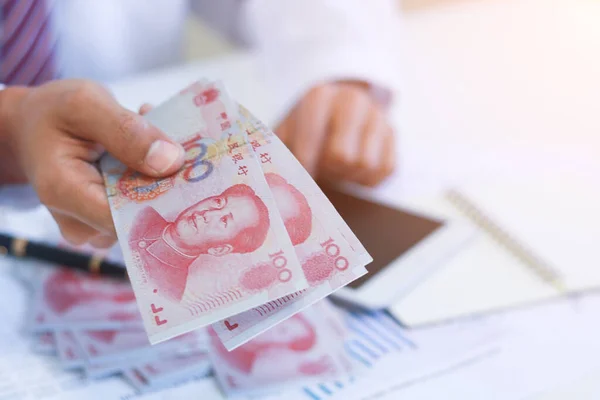Businessman with money in hand, Yuan,investment, success and profitable business concepts.