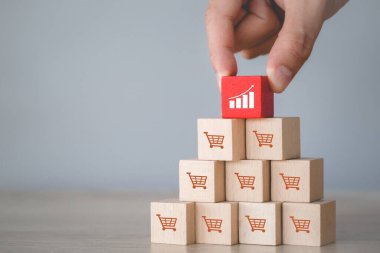 Hand arranging wood block stacking with icon Graph and shopping cart symbol upward direction,