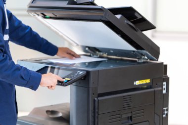 İşadamı, yazıcı fotokopi ağı panelindeki düğmeye basar, ofis konseptinde fotokopi üzerinde çalışır, yazıcı, kağıt tarama ve kopyalama için ofis çalışanı ekipmanıdır.