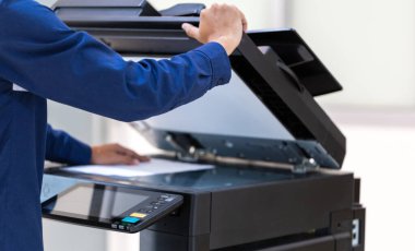 İşadamı, yazıcı fotokopi ağı panelindeki düğmeye basar, ofis konseptinde fotokopi üzerinde çalışır, yazıcı, kağıt tarama ve kopyalama için ofis çalışanı ekipmanıdır.