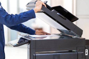 İşadamı, yazıcı fotokopi ağı panelindeki düğmeye basar, ofis konseptinde fotokopi üzerinde çalışır, yazıcı, kağıt tarama ve kopyalama için ofis çalışanı ekipmanıdır.