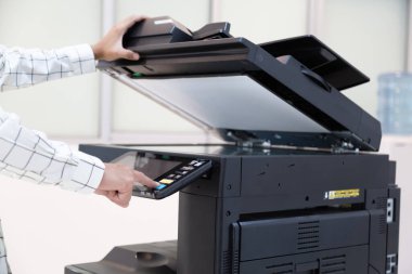 İşadamı, yazıcı fotokopi ağı panelindeki düğmeye basar, ofis konseptinde fotokopi üzerinde çalışır, yazıcı, kağıt tarama ve kopyalama için ofis çalışanı ekipmanıdır.