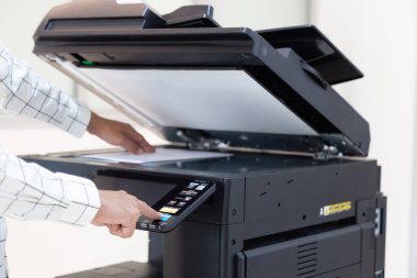 İşadamı, yazıcı fotokopi ağı panelindeki düğmeye basar, ofis konseptinde fotokopi üzerinde çalışır, yazıcı, kağıt tarama ve kopyalama için ofis çalışanı ekipmanıdır.