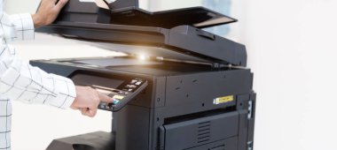 İşadamı, yazıcı fotokopi ağı panelindeki düğmeye basar, ofis konseptinde fotokopi üzerinde çalışır, yazıcı, kağıt tarama ve kopyalama için ofis çalışanı ekipmanıdır.