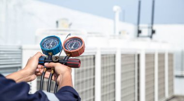 Teknisyen klimayı kontrol ediyor, klimaları, servis ve bakım klimalarını doldurmak için ölçüm aletleri kullanıyor. .