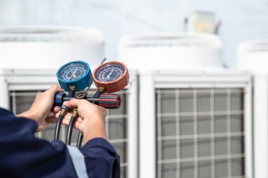 Teknisyen klimayı kontrol ediyor, klimaları, servis ve bakım klimalarını doldurmak için ölçüm aletleri kullanıyor. .