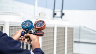 Teknisyen klimayı kontrol ediyor, klimaları, servis ve bakım klimalarını doldurmak için ölçüm aletleri kullanıyor. .