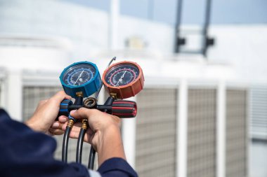 Teknisyen klimayı kontrol ediyor, klimaları, servis ve bakım klimalarını doldurmak için ölçüm aletleri kullanıyor. .